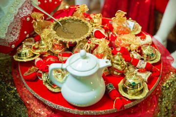 Mixing henna for hair. Natural henna color mixed pasted in a bowl. Henna the table . Golden decoration for the henna .