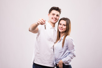 Joyful young couple with a pair of keys isolated on white
