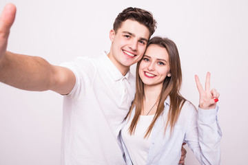 Handsome man making selfie with his pretty woman isolated on white backgroud