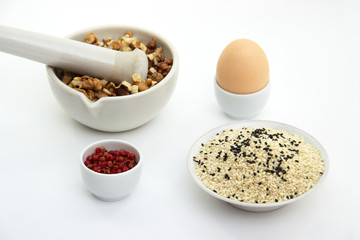 keto crackers recipe ingredients. Walnuts in mortar for grinding, egg, black and white sesame...
