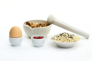 keto crackers recipe ingredients. Walnuts in mortar for grinding, egg, black and white sesame...