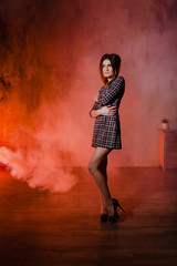 Naklejka premium Brunette posing in a cloud of orange smoke