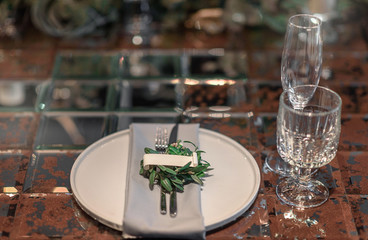 Mirror table served with plates, forks, spoons, glasses,  napkins in the restaurant. Beautiful festive table