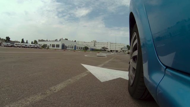 Blue car during passing driving license exam outdoors on asphalt autodrome