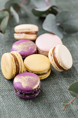 Close-up colorful French or Italian macaron on white wooden table. Macarons is French dessert served with tea or coffee. wallpaper, Vertical photo