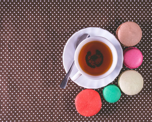 Fototapety  Colorful french macaroons with cup of tea. Top view