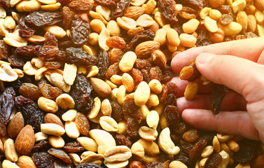 Background with a cashew, hazelnuts, raisins and peanuts. Assorted nuts and raisins with a place...