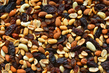 Background with a cashew, hazelnuts, raisins and peanuts. Mixed nuts and raisins texture.