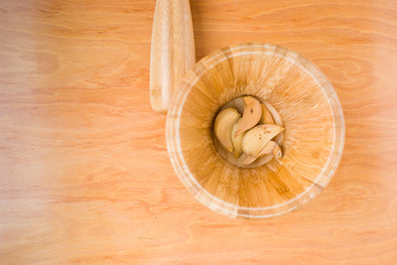 mortar with dried garlic in horizontal photo on wooden background