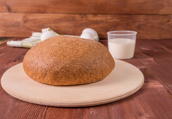 Grain round bread on a wooden board.