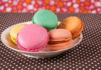Colorful French or Italian macaroons stack on white plate put on table