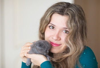 Woman holding gray scottish fold kitten