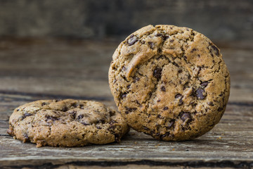 Two Freshly Baked Chocolate Cookies on Rustic Wooden Table. Sweet Biscuits. Homemade pastry.