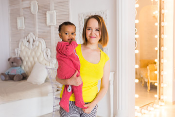 Loving Mother Holding Mixed Race Baby Boy At Home