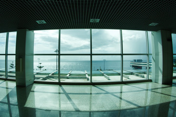 Interior airport architecture background. Big transparent glass and reflective floor.