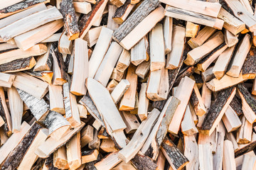 chaotically arranged in a pile of fresh chopped firewood, abstract background