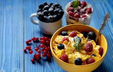 Healthy breakfast. corn flakes with raspberries and blueberries and granola with yogurt and berries.