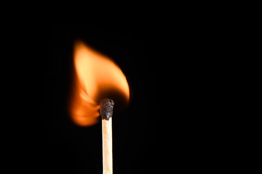 Match with strongly and evenly burning flame on a black background closeup