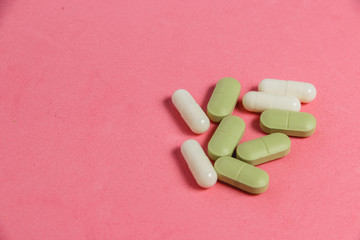 Assortment of Pills, Tablets and Capsules on Pink Table.