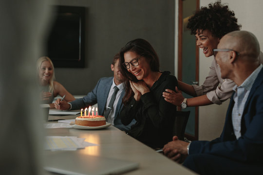 Business team celebrating female colleague's birthday