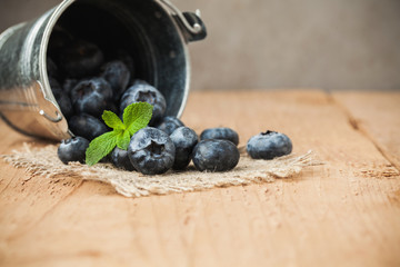 Blueberry on wooden table background. Ripe and juicy fresh picked blueberries closeup. Berries closeup with copy space