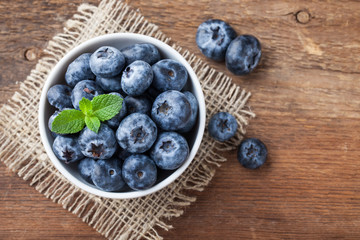 Blueberry on wooden table background. Ripe and juicy fresh picked blueberries closeup. Berries closeup top view with copy space