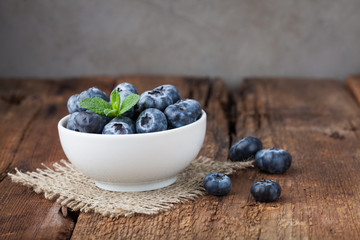 Blueberry on wooden table background. Ripe and juicy fresh picked blueberries closeup. Berries closeup with copy space