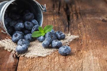 Blueberry on wooden table background. Ripe and juicy fresh picked blueberries closeup. Berries closeup with copy space
