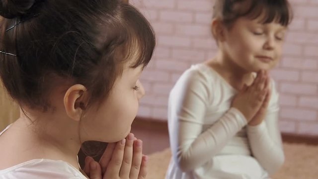 Namaste. A child in a yoga pose.