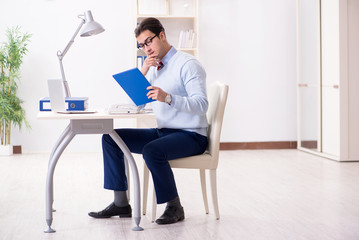 Young handsome businessman employee working in office at desk