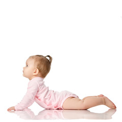 Naklejka premium 8 month infant child baby girl toddler lying in pink shirt looking at corner isolated on a white
