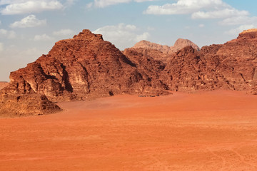 Fototapeta na wymiar Red mountains of the canyon of Wadi Rum desert in Jordan. Wadi Rum also known as The Valley of the Moon is a valley cut into the sandstone and granite rock in southern Jordan to the east of Aqaba.