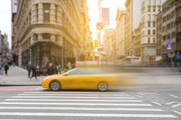 New York City yellow taxi cab in motion across broadway