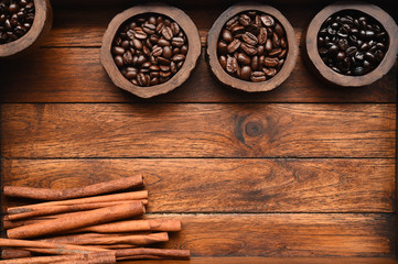 Close up of coffee beans in wooden bowl and cinnamon