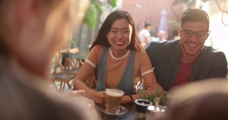 Young multi-ethnic hipster couple having fun with friends at cafe - Powered by Adobe