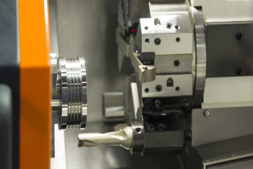 The CNC lathe machine cutting the stainless thread part with