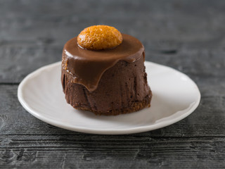 Cake on a white plate on a dark rustic table.