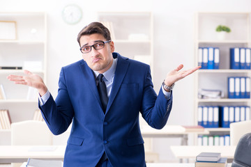 Young handsome businessman employee working in office at desk