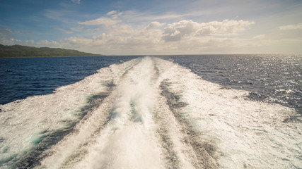 A trail of sea water foam follows the ferry to the island of Palawan. Philippines. Shooting in motion.