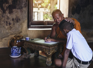 Monk teaching children books in rural temples.