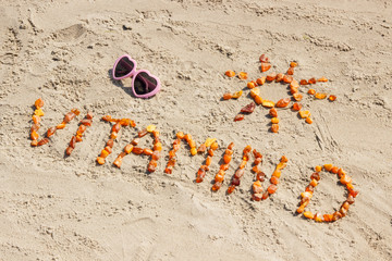 Obraz premium Sunglasses, inscription vitamin D and shape of sun on sand at beach, summer time and healthy lifestyle concept