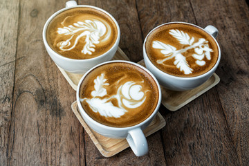 Top view of coffee cup set which consist of latte art and capuchino ooer the wooden table, drink and coffee shop concept