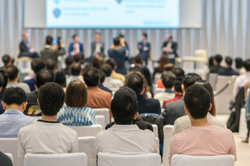 Rear view of Audience in the conference hall or seminar meeting which have Speakers on the stage, business and education about investment concept