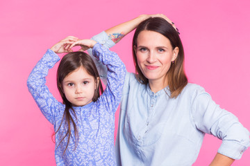 Funny woman and kid over pink background. Happy family playing in home