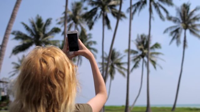 girl tourist taking pictures on palm phone