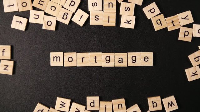 Many letters move on a black table and then sets up a word "Mortgage"