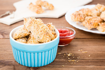 Homemade nuggets from chicken in a bowl on a wooden table