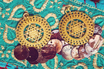 golden plated earrings on blue decorative textile