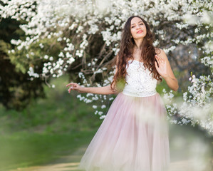 Fototapeta premium Young woman in the garden blooming in spring