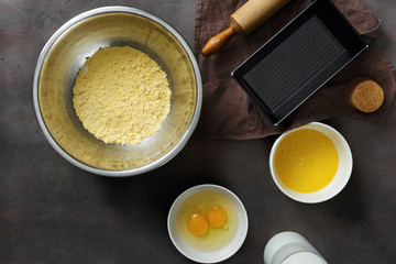Raw ingredients for cooking corn bread on dark background top view